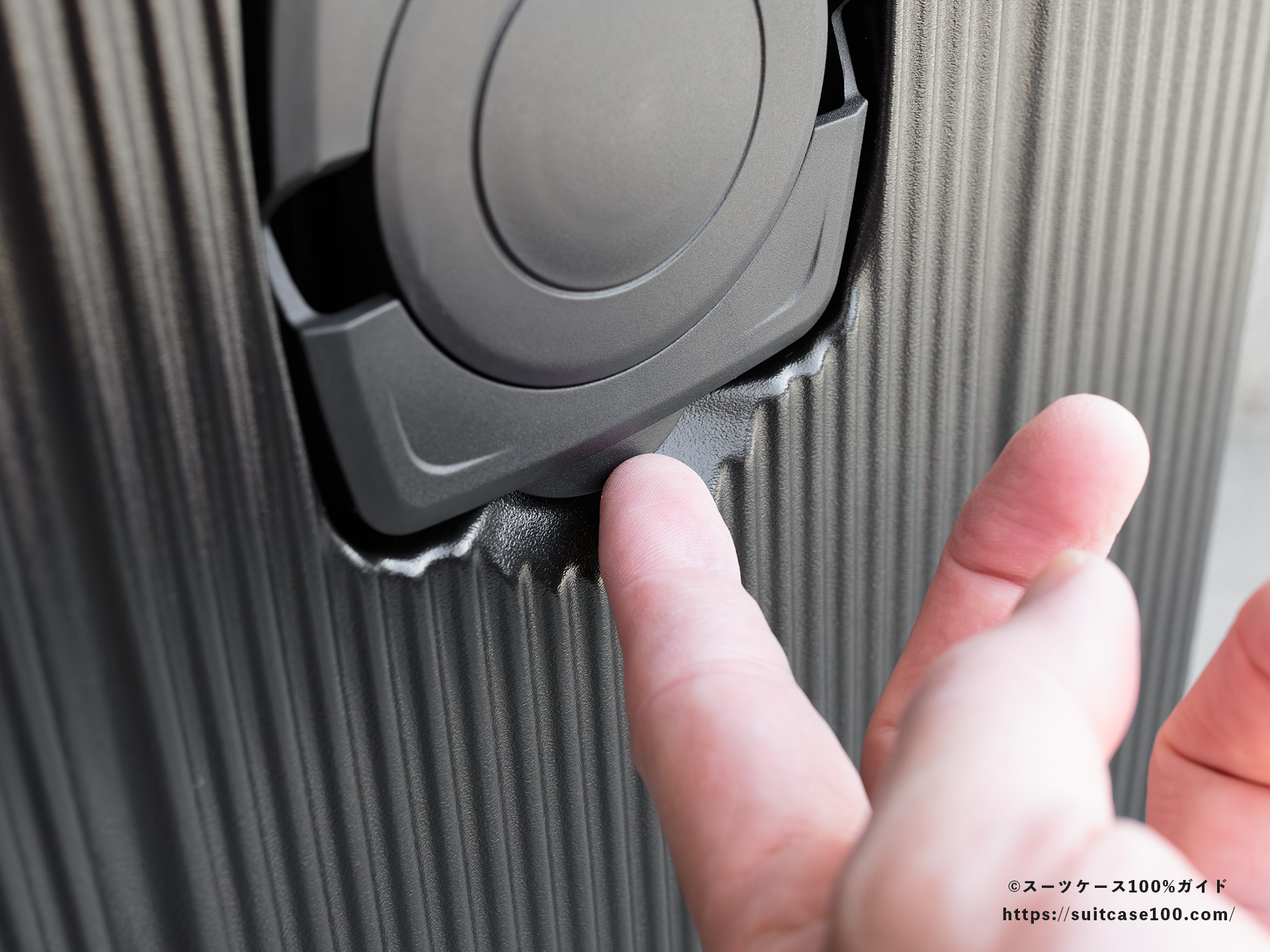 3COINS(スリーコインズ) 機内持ち込みサイズスーツケース ドリンクホルダーレビュー 指先で引っ張っている図