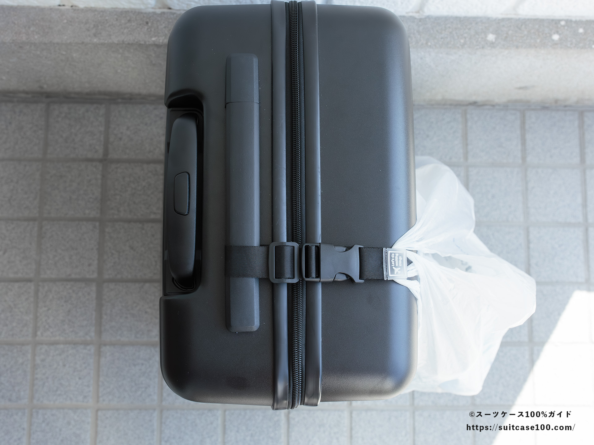 ダイソー スーツケースと手荷物まとめベルト レビュー トップハンドルの端に通した状態拡大