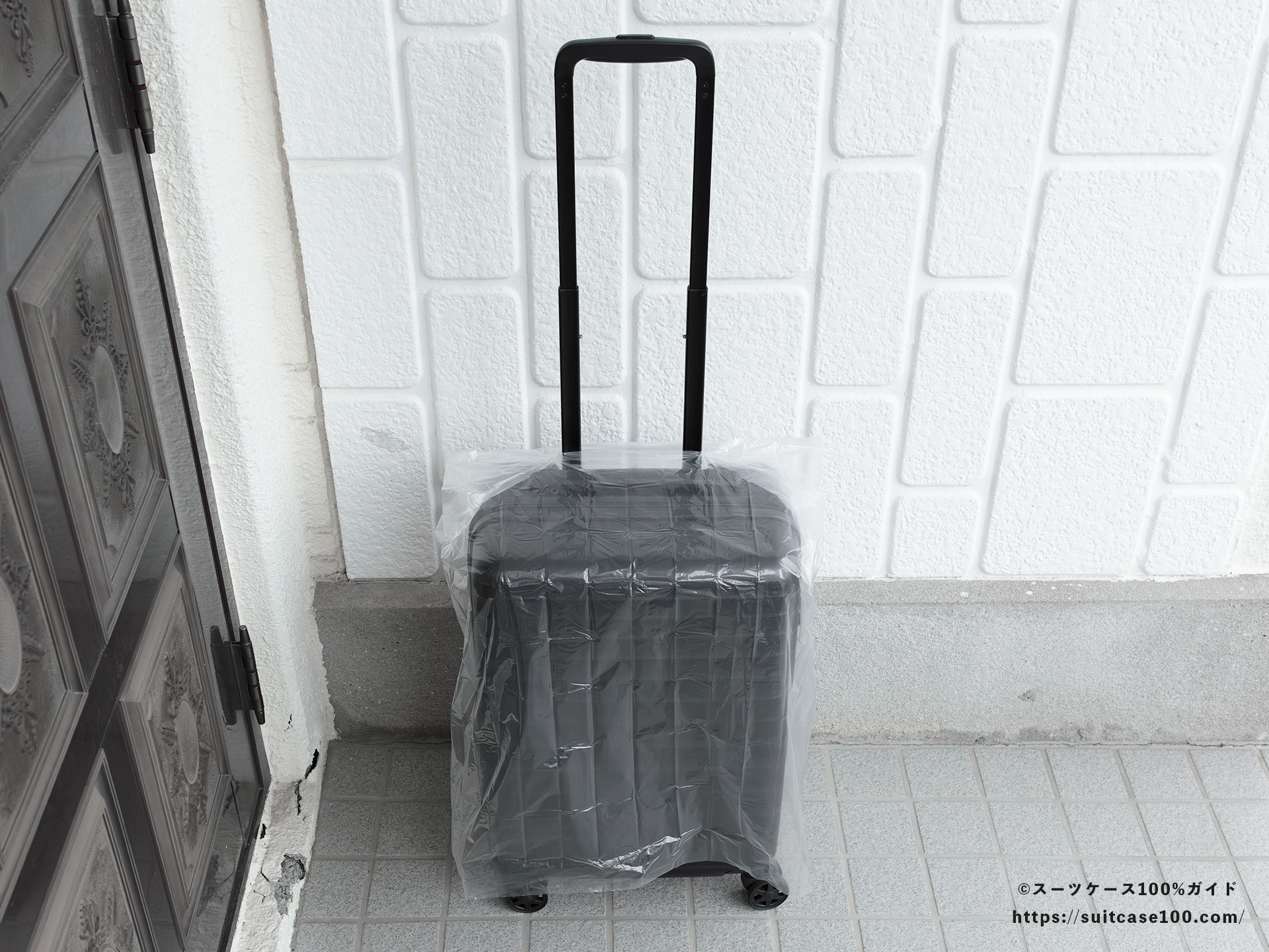 ダイソー レインバッグカバー(キャリーバッグ用) レビュー Sサイズのスーツケースに装着してキャリーハンドルも通した図
