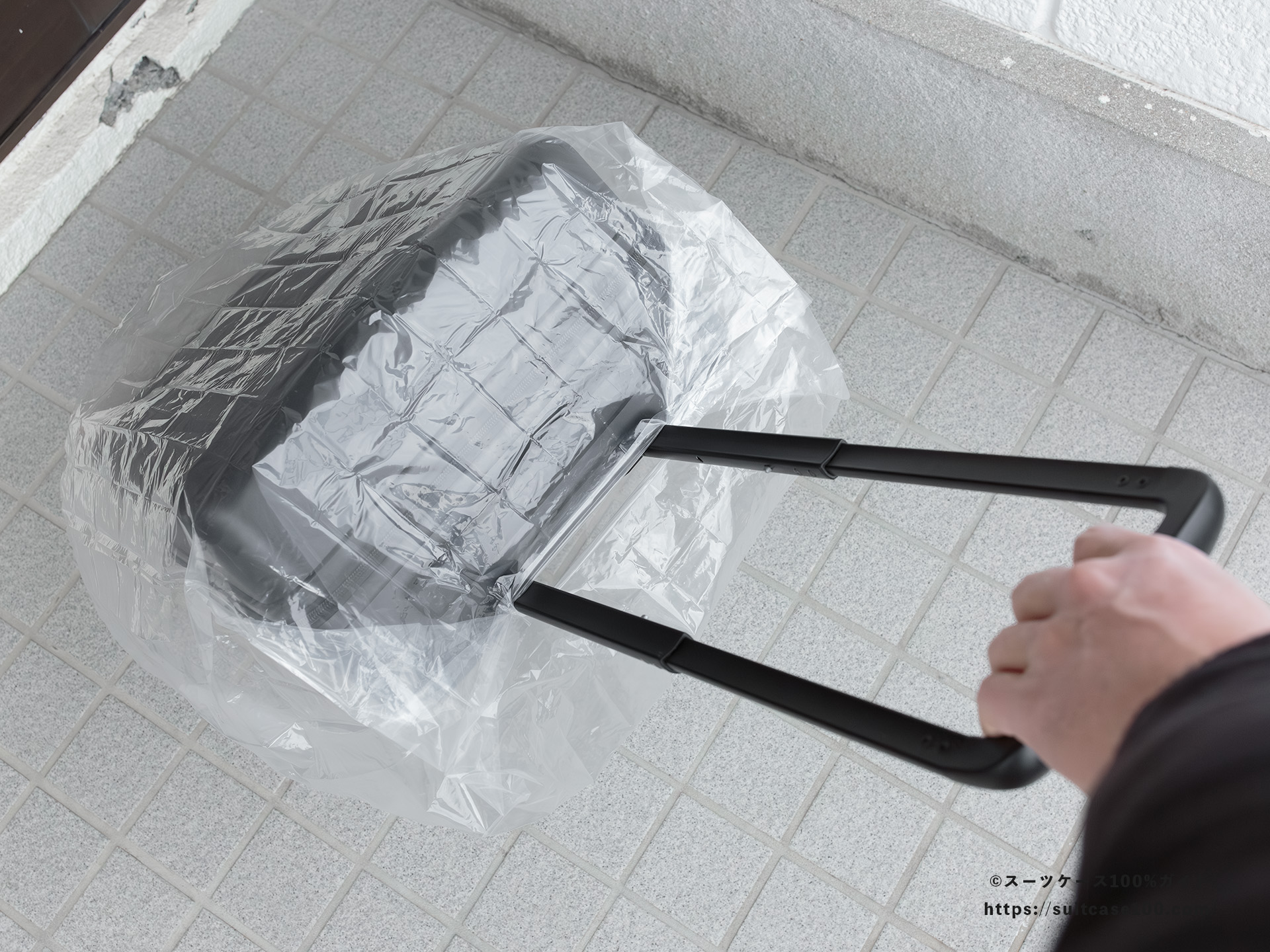 ダイソー レインバッグカバー(キャリーバッグ用) レビュー スーツケースに装着して転がしている図