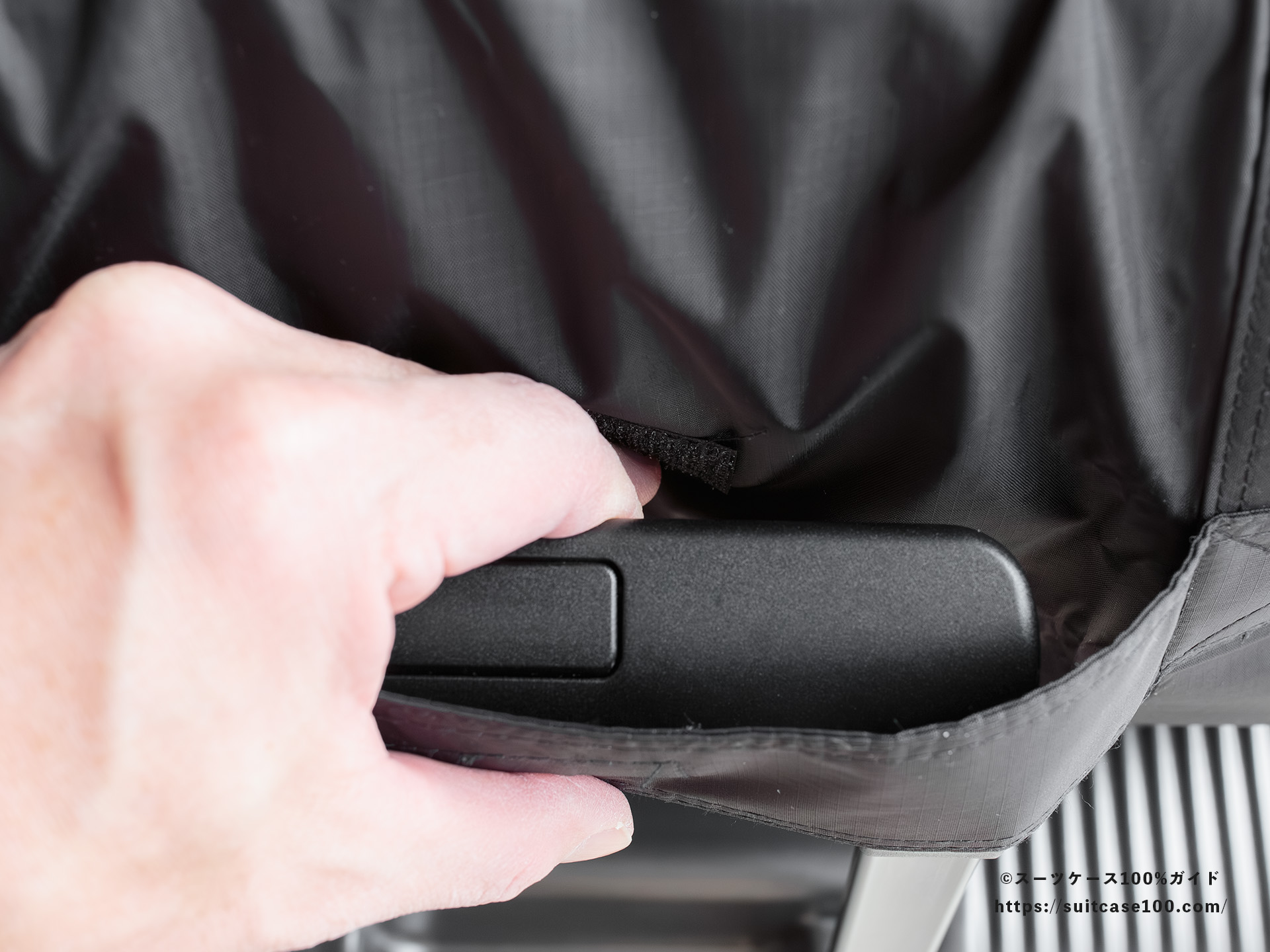 LAKOLE キャリーオンボストンバッグ レビュー Lサイズのスーツケースに装着してキャリーハンドルを握っている図